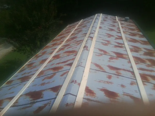 Rusted metal roof panels with new wood purlins before replacement — Storm Damage Roof Repair in East Orange by Roofing Brothers