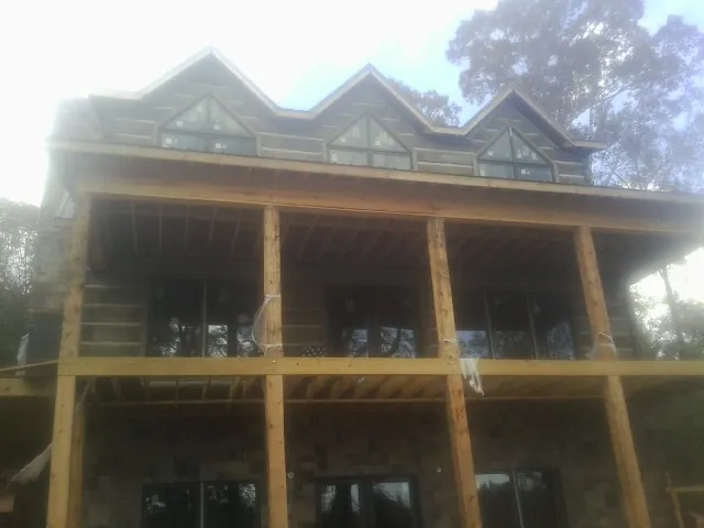 Dormers and porch framing on a large log home under construction — Roof Coating work by our crew in East Orange